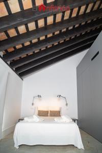 sypialnia z białymi ścianami i dużym białym łóżkiem w obiekcie Bodega Mar - Velo de Flor w mieście Sanlúcar de Barrameda