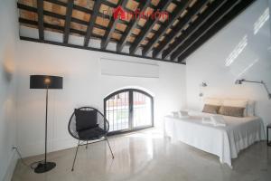 sypialnia z łóżkiem i krzesłem w pokoju w obiekcie Bodega Mar - Velo de Flor w mieście Sanlúcar de Barrameda