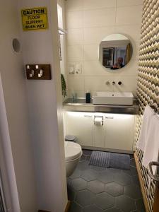 a bathroom with a toilet and a sink and a mirror at The Jazz Quarters, Southsea's hidden gem in Portsmouth