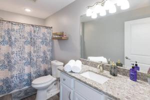 a bathroom with a toilet and a sink and a mirror at The Sanctuary Company Johnson City in Johnson City +21 photos