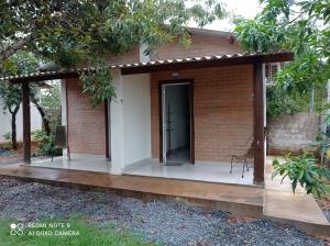 a small brick house with a black door at Casa Stúdio Uirá - suíte in Chapada dos Guimarães