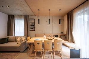 a living room with a table and chairs and a couch at Lebe`oetz - Das Ferienapartmenthaus im Zentrum von Oetz in Oetz