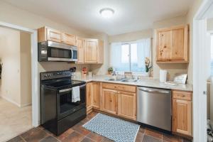 a kitchen with wooden cabinets and a stove and a sink at The Sanctuary Company Johnson City in Johnson City