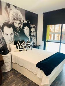 ein Schlafzimmer mit einem Bett mit einem Wandbild von Männern in der Unterkunft T-Homes Salamanca in Madrid