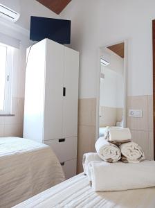 a white bedroom with a bed and a mirror at Casa Ponto de Encontro in Almodôvar