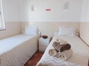 two beds sitting next to each other in a room at Casa Ponto de Encontro in Almodôvar