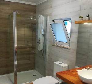 a bathroom with a shower and a toilet and a sink at Alo Baía São Lourenço in Santa Bárbara
