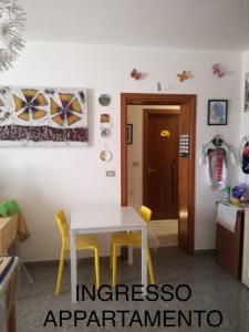 een kamer met een witte tafel en gele stoelen bij Affittacamere Girasole in Foligno