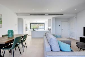 ein Wohnzimmer und eine Küche mit einem Sofa und einem Tisch in der Unterkunft 085 Modern Apartment in Trendy La Cala Golf Resort in Málaga