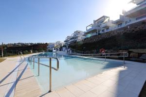 una piscina di fronte ad alcuni edifici di 085 Modern Apartment in Trendy La Cala Golf Resort a Málaga