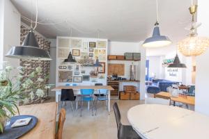 a dining room with tables and chairs and pendant lights at Moinho Calmo in Vila do Bispo