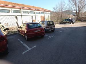 due auto parcheggiate in un parcheggio accanto a un edificio di Mimi a Šibenik