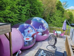 dos cúpulas de burbujas en una terraza con mesa y sillas en La Bulle Des Anges, en Illoud