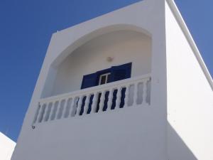 a white building with a blue window on it at Fotini & Dimitrios in Frý
