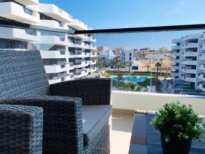 a balcony with wicker chairs and a view of a building at Sol Blanco in Arenales del Sol