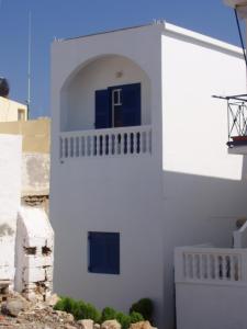 a white building with a blue door at Fotini & Dimitrios in Frý