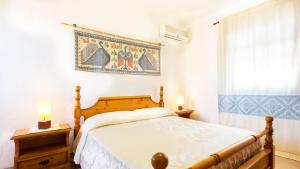 a bedroom with a bed and a rug on the wall at Case Vacanza Aiosardegna Porto Columbu in Porto Columbu - Perdʼe Sali