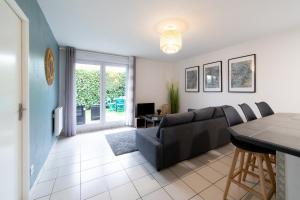 uma sala de estar com um sofá e uma mesa em My Cozy Flat Blagnac - T2 - Free Parking - Terrasse - Jardin em Blagnac