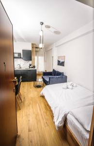 a bedroom with a white bed and a blue couch at Dreamy Apartment City Center 7 thesbnbgr in Thessaloniki