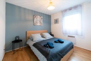 1 dormitorio con 1 cama con 2 toallas en My Cozy Flat Blagnac - T2 - Free Parking - Terrasse - Jardin, en Blagnac