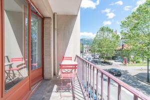 een balkon met rode stoelen en een tafel bij Apartment with balcony in the city center in Annecy