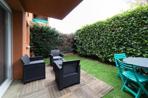 un patio con sillas, una mesa y una mesa con sillas en My Cozy Flat Blagnac - T2 - Free Parking - Terrasse - Jardin, en Blagnac