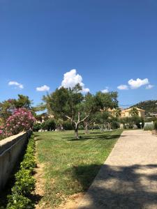 a park with trees and grass and a sidewalk at Aloni Studios and Apartments in Lassi