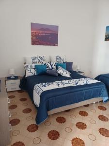 a bedroom with a bed with blue and white sheets at Il Ponte in Naples