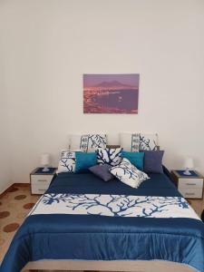 een slaapkamer met een blauw en wit bed met kussens bij Il Ponte in Napels