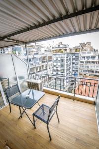 uma varanda com uma cadeira e uma mesa num edifício em Dreamy Apartment City Center 7 thesbnbgr em Tessalônica