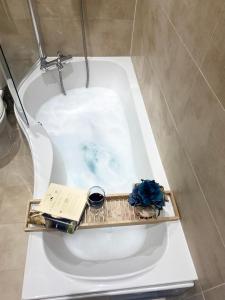 a bath tub with a book and a book at THE MOST CENTRAL Apartment in Canterbury Stunning Interiors, fully equipped, City Views and Free WiFi! in Kent +51 photos