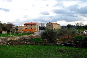 a group of buildings in a grassy field at Casa de l Puio in Picote