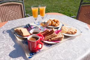 a tray of breakfast food on a table with two glasses of orange juice at Ουρανια Τασιου in Mikro Chorio