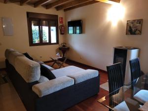sala de estar con sofá y chimenea en El Cameliar - Vibañu, en Vibaño