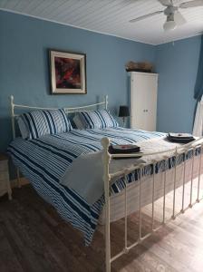 1 dormitorio con 1 cama con paredes azules en Le Breil Furet, en Ménéac