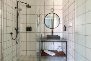 a bathroom with a sink, mirror, and towel rack at Selina Neve Tzedek Tel Aviv in Tel Aviv