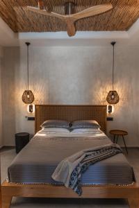 a bedroom with a large bed with two lights at Almyra Oia Suites in Oia