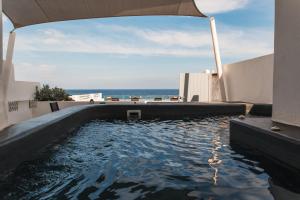 a swimming pool with a view of the ocean at Almyra Oia Suites in Oia