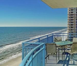 balkon ze stołem i krzesłami oraz oceanem w obiekcie Sterling Breeze 1007 w mieście Panama City Beach