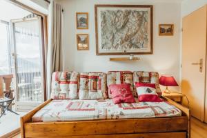 a bedroom with a bed with red pillows at Furnished studio at the foot of the slopes with a balcony & mountains view in Saint-Gervais-les-Bains