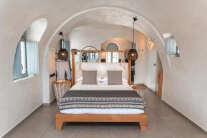a bedroom with a bed and a dresser at Almyra Oia Suites in Oia