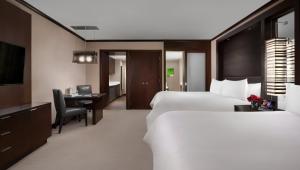 a hotel room with two beds and a desk and a television at Vdara Hotel & Spa at ARIA Las Vegas in Las Vegas