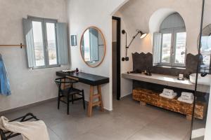 a bathroom with a large mirror and a large window at Almyra Oia Suites in Oia