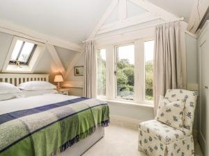 - une chambre avec un lit, une chaise et des fenêtres dans l'établissement The Barn at Frog Pond Farm, à Salisbury