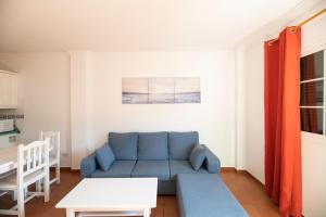 ein Wohnzimmer mit einem blauen Sofa und einem Tisch in der Unterkunft Hotel Apartamentos Villa Gomera in San Sebastián de la Gomera