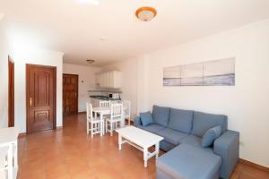 a living room with a blue couch and a table at Hotel Apartamentos Villa Gomera in San Sebastián de la Gomera