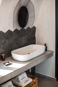 a bathroom with a white sink and a mirror at Almyra Oia Suites in Oia