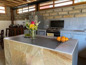 una cocina con una barra con un jarrón de flores en Balneario Punta Sal, en Canoas de Punta Sal