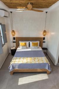 a bedroom with a large bed with yellow pillows at Almyra Oia Suites in Oia