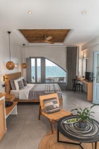 1 dormitorio con 1 cama y vistas al océano en Almyra Oia Suites, en Oia